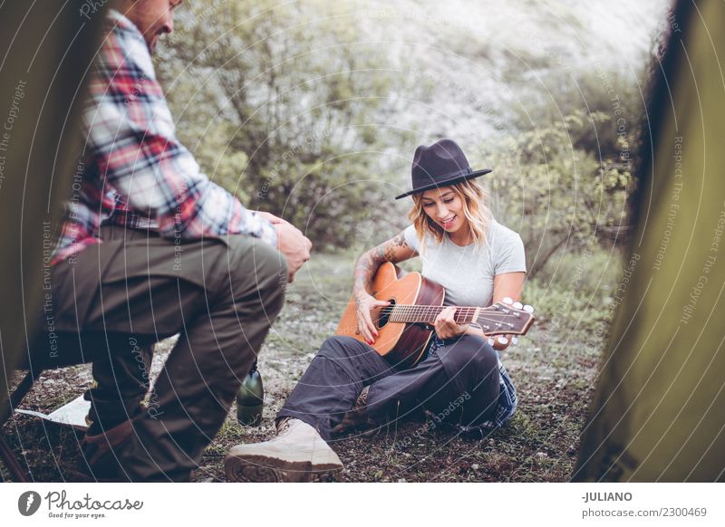 Junges Camping-Paar, das eine gute Zeit mit Gitarrenmusik hat. Lifestyle Ferien & Urlaub & Reisen Ausflug Abenteuer Ferne Freiheit Berge u. Gebirge wandern