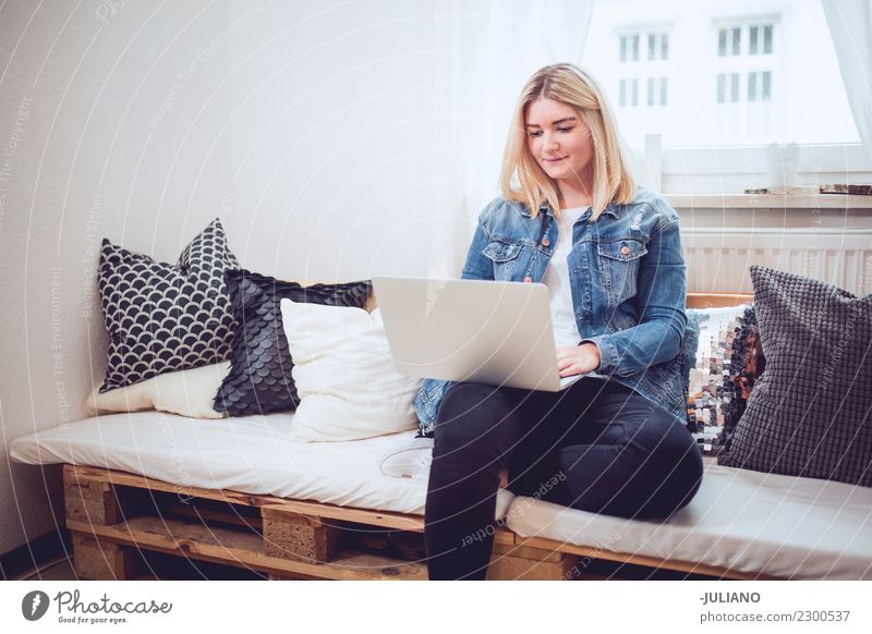 Junge Frau, die auf diy Couch arbeitet mit Notizbuch sitzt Lifestyle kaufen Häusliches Leben Wohnung Innenarchitektur Raum Wohnzimmer Mensch feminin Jugendliche
