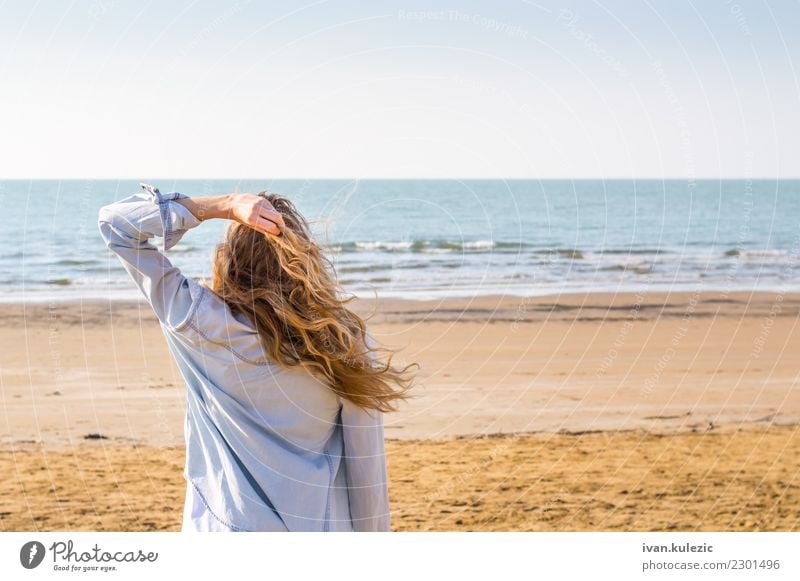 Blondes Mädchen, das in Richtung des Meeres blickt Lifestyle Freude Erholung Ferien & Urlaub & Reisen Sommer Sonne Sonnenbad Strand Frau Erwachsene Sand Küste