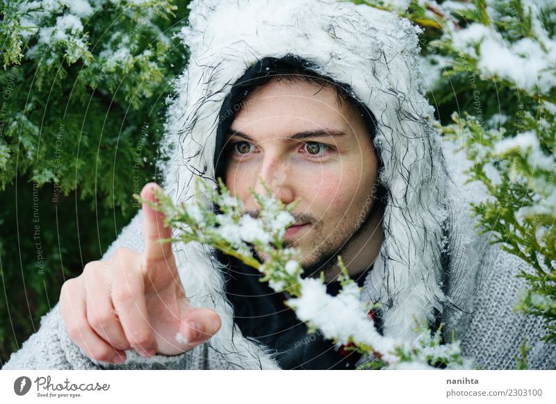 Junger Mann, der eine schneebedeckte Niederlassung berührt Lifestyle Stil Mensch maskulin Jugendliche Erwachsene 1 30-45 Jahre Umwelt Natur Winter Klima Wetter