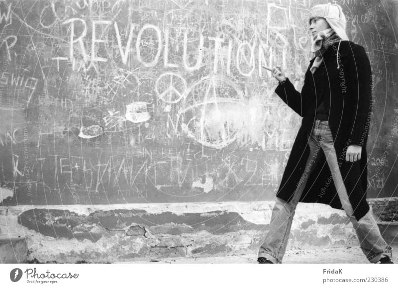 Revolution feminin Junge Frau Jugendliche Jugendkultur lesen Fassade Bekleidung Jeanshose Mantel Accessoire Mütze Stein Schriftzeichen Denken kämpfen