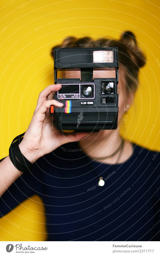 Young woman holding an instant camera in front of her face Lifestyle feminin Junge Frau Jugendliche Erwachsene 1 Mensch 18-30 Jahre Freizeit & Hobby