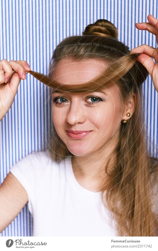 Young woman fooling around with her hair Lifestyle Stil feminin Junge Frau Jugendliche Erwachsene 1 Mensch 18-30 Jahre schön lustig spaßig Haarsträhne