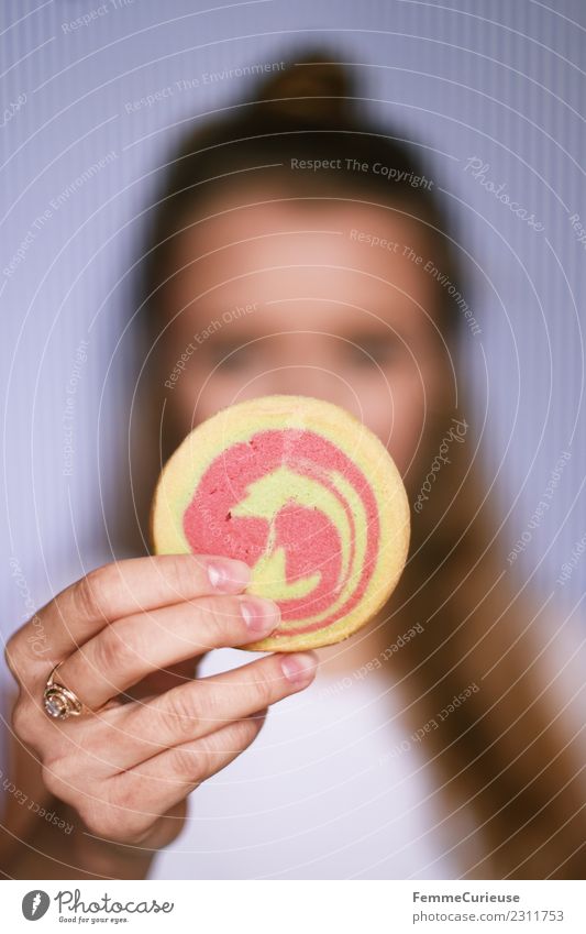 Young woman showing cookie into the camera Lebensmittel Junge Frau Jugendliche Erwachsene 1 Mensch 18-30 Jahre genießen Mürbeplätzchen Cookie Backwaren Süßwaren