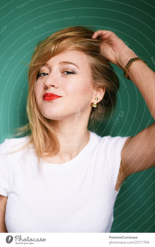 Young blonde woman posing in front of turquoise background elegant Stil feminin Junge Frau Jugendliche Erwachsene 1 Mensch 18-30 Jahre schön Körperhaltung Model