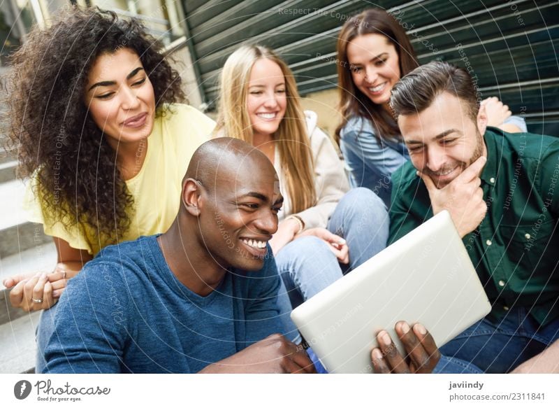 Multiethnische Gruppe junger Menschen, die sich im Freien einen Tablet-Computer ansehen Lifestyle Freude Glück schön Junge Frau Jugendliche Junger Mann