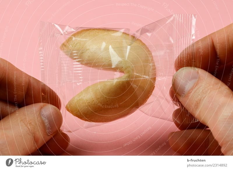 Glückskeks verpackt Süßwaren Mann Erwachsene Finger 30-45 Jahre wählen festhalten rosa Schutz Zukunftsangst entdecken Hoffnung Keks Verpackungsmaterial