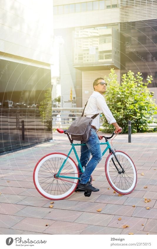 Ein junger, stilvoller Mann, der neben seinem Fahrrad posiert. Erholung Sport Erwachsene Jugendliche Jugendkultur Straße Mode Jeanshose Brille Glatze Lächeln