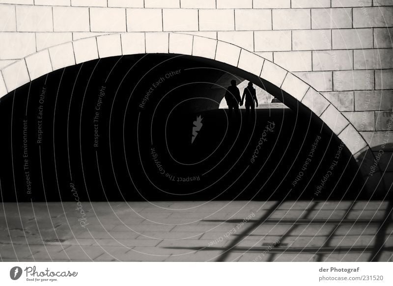 hand in hand Spaziergang Mensch maskulin Frau Erwachsene Mann Paar Partner 2 Brücke Tunnel Mauer Wand Wege & Pfade Stein gehen zusammengehörig Schwarzweißfoto