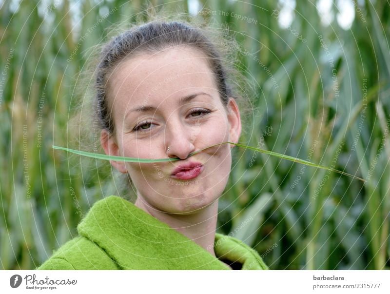 Kurioses | junge Frau mit grasgrünem Schnurrbart feminin Erwachsene 1 Mensch Natur Pflanze Herbst Klima Gras Maisfeld Feld Jacke Oberlippenbart Locken Lächeln