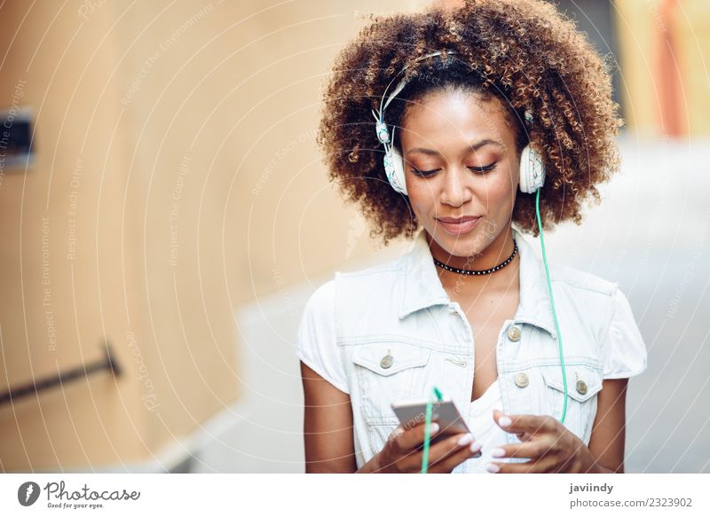 Schwarze Frau, die die Musik über Kopfhörer hört. Lifestyle Stil Freude Glück schön Haare & Frisuren Gesicht Telefon PDA Mensch Junge Frau Jugendliche
