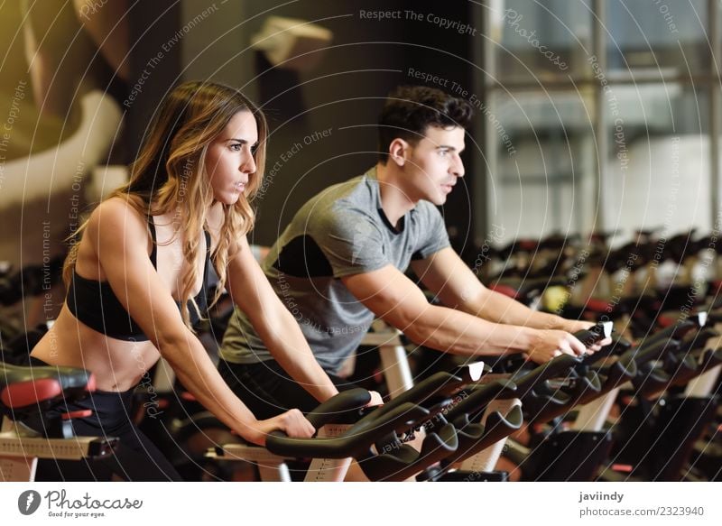 Zwei Menschen Radfahren in der Turnhalle, trainieren Beine tun Cardio-Workout Radfahren Fahrräder Lifestyle Freizeit & Hobby Sport Arbeit & Erwerbstätigkeit
