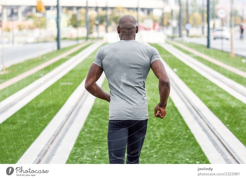 Rückansicht eines schwarzen Mannes, der im urbanen Hintergrund läuft. Lifestyle Körper Sport Joggen Mensch maskulin Junger Mann Jugendliche Erwachsene 1