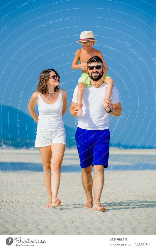 Fröhliche junge dreiköpfige Familie am Strand Lifestyle Freude Spielen Sommer Meer Insel Kindheit Menschengruppe Sonnenbrille Vollbart Lächeln Fröhlichkeit