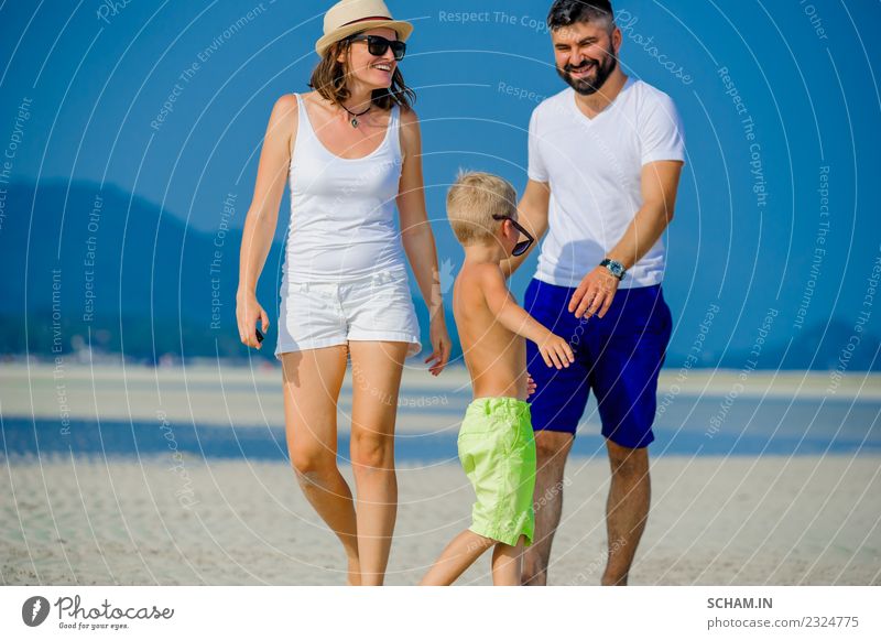 Glückliche junge Dreierfamilie Lifestyle Freude Spielen Sommer Meer Insel Kindheit Menschengruppe Sonnenbrille Vollbart Lächeln Fröhlichkeit Zusammensein