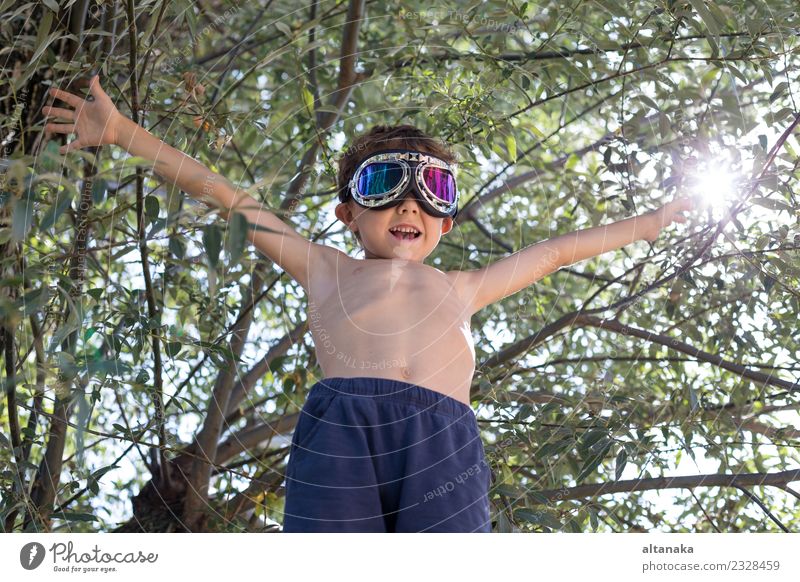 Fröhlicher kleiner Junge spielt im Freien in der Nähe eines Baumes Lifestyle Freude Glück Spielen Ferien & Urlaub & Reisen Ausflug Abenteuer Freiheit Sommer