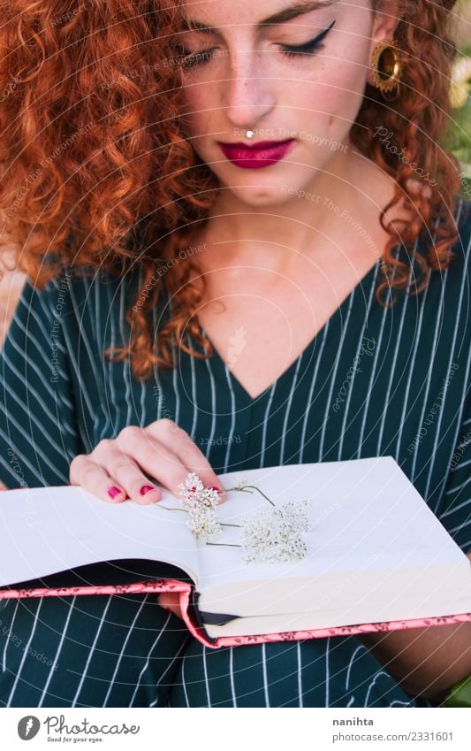 Junge rothaarige Frau hält ein offenes Buch. Lifestyle elegant Stil schön Haare & Frisuren Haut Gesicht Schminke Freizeit & Hobby Schüler Mensch feminin