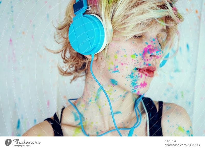 Junge Frau mit Farbe im Gesicht hört Musik. Lifestyle Stil Design exotisch Erholung ruhig Freizeit & Hobby Technik & Technologie Unterhaltungselektronik Mensch