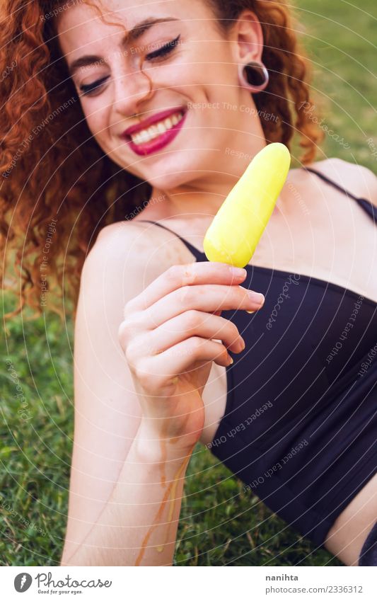 Junge Frau im Freien, die ein Zitroneneis hält. Lebensmittel Speiseeis Essen Lifestyle Stil Freude schön Haare & Frisuren Haut Gesicht Sommer Sommerurlaub