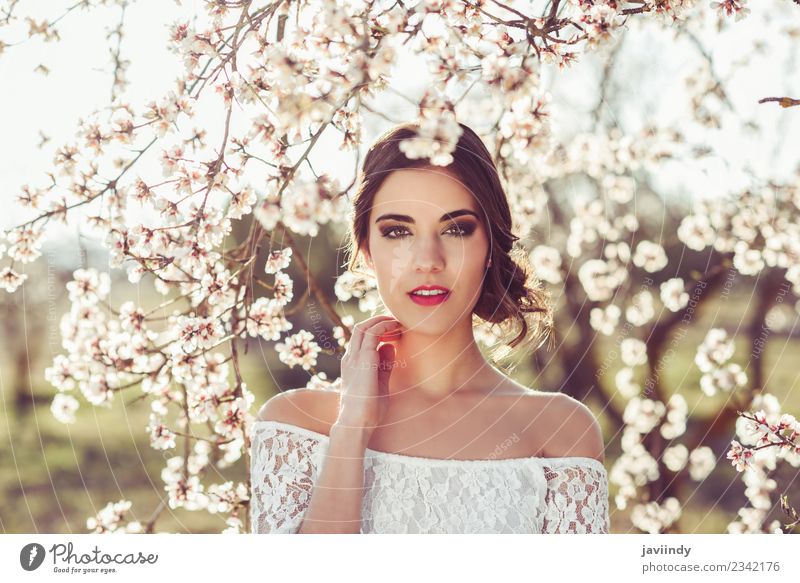 Junge Frau zwischen den Mandeln blüht im Frühling. Stil schön Mensch feminin Jugendliche Erwachsene 1 18-30 Jahre Natur Baum Blume Mode Kleid brünett weiß