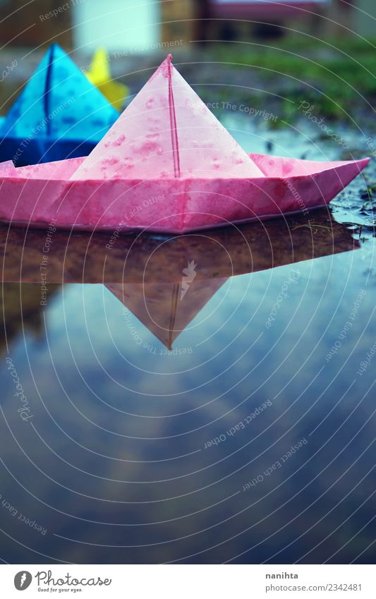 Bunte Papierboote im Wasser Umwelt Natur Wassertropfen Herbst Winter Klima Wetter schlechtes Wetter Regen Spielzeug Papierschiff Pfütze authentisch einfach