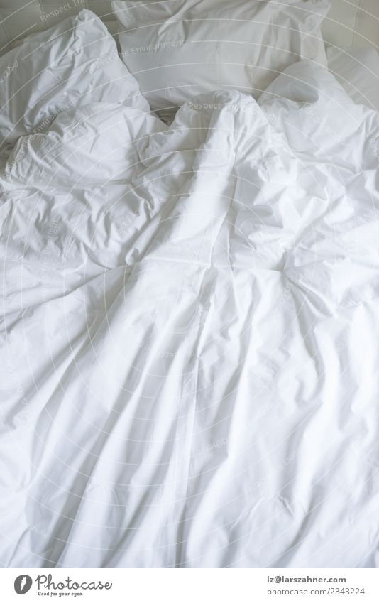 Ungemachtes Bett mit schlichter weißer Bettwäsche Wohnung Schlafzimmer Stoff schlafen weich Geborgenheit bequem ungemacht Leinen beschmutzen Hotel Entwurf