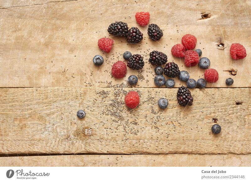 Verschiedene Beeren und Chiasamen auf altem Holztisch Lebensmittel Frucht Ernährung Bioprodukte Vegetarische Ernährung Diät Lifestyle Gesunde Ernährung Essen