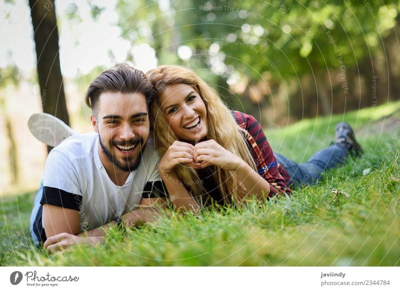 Schönes junges Paar, das auf Gras in einem Stadtpark liegt. Lifestyle Freude Glück schön Sommer Mensch Junge Frau Jugendliche Junger Mann Erwachsene 2
