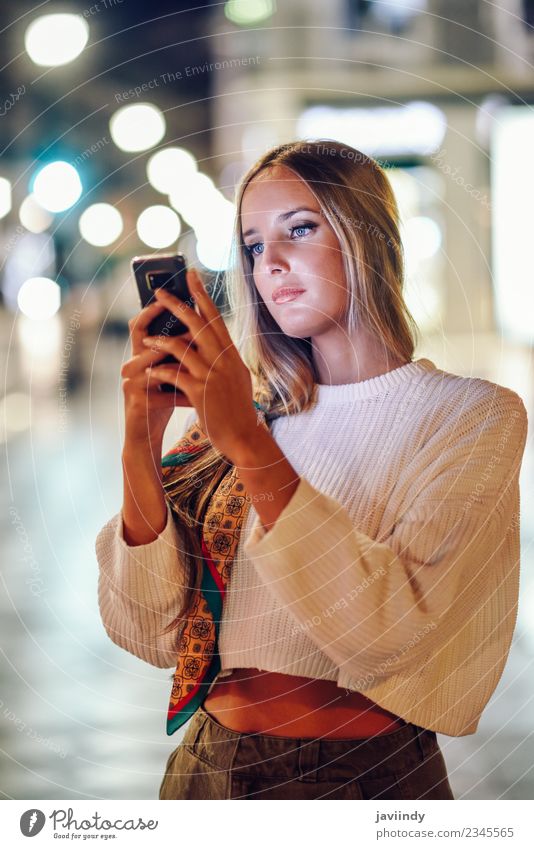 Blonde Frau fotografiert nachts auf der Straße mit ihrem Smartphone Lifestyle Stil schön Haare & Frisuren Telefon PDA Fotokamera Mensch Junge Frau Jugendliche