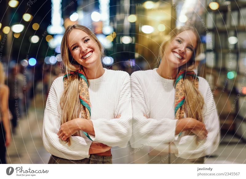 Junge Frau in der Nacht, die sich in einem Schaufenster spiegelt. Stil schön Mensch feminin Jugendliche Erwachsene 1 18-30 Jahre Straße Mode Bekleidung blond