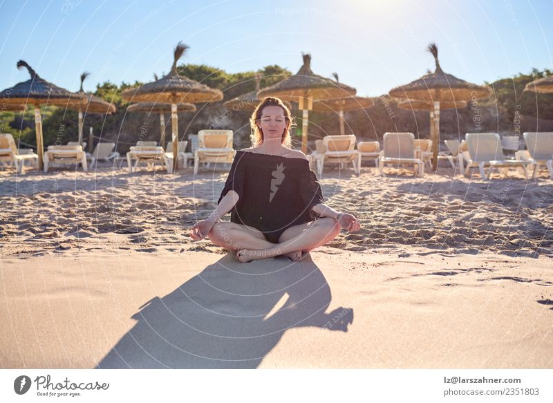 Attraktive Barfuß-Frau, die am Strand meditiert. Glück Erholung ruhig Meditation Freizeit & Hobby Ferien & Urlaub & Reisen Sommer Yoga Erwachsene Sand sitzen