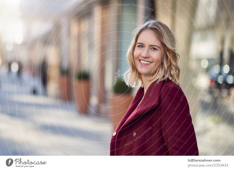 Attraktive blonde Frau in einer Stadtstraße Lifestyle Glück schön Mensch Erwachsene 1 18-30 Jahre Jugendliche Herbst Wärme Straße Mode Mantel Lächeln weiß