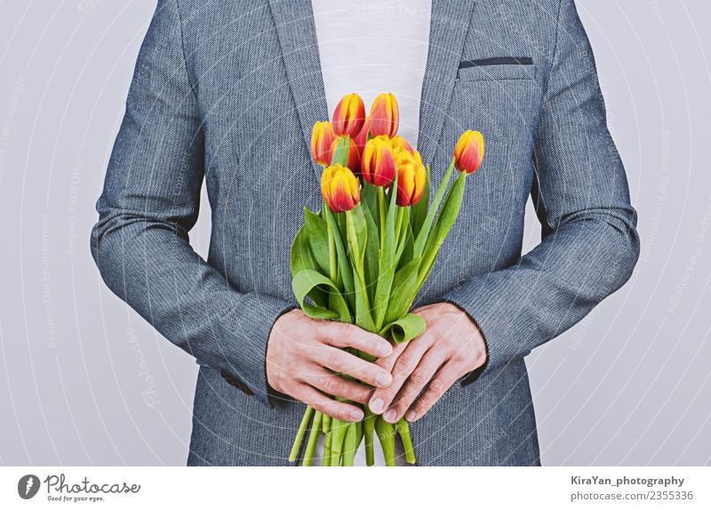 Mann in blauer Jacke mit Tulpenstrauß Glück schön Flirten Feste & Feiern Valentinstag Mensch Erwachsene Mutter Blume Vollbart Blumenstrauß Liebe gelb rot weiß