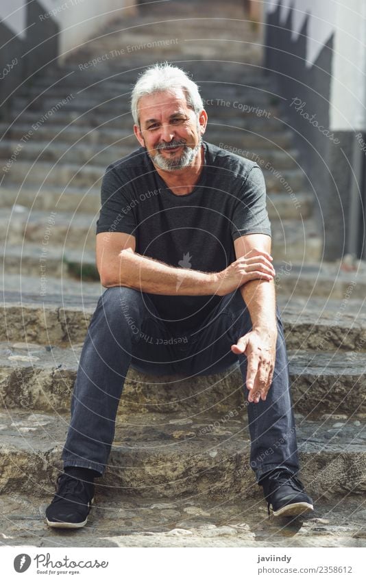 Ein reifer Mann, der auf einer Treppe auf einer Treppe sitzt und lächelt. Lifestyle Glück Mensch Erwachsene Männlicher Senior 1 45-60 Jahre 60 und älter Straße