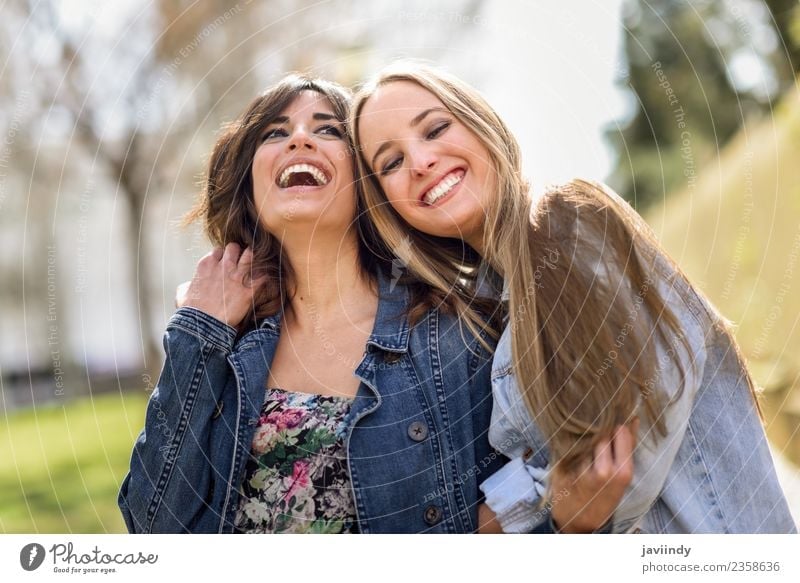 Zwei glückliche junge Freundinnen, die sich auf der Straße umarmen. Lifestyle Freude Mensch feminin Junge Frau Jugendliche Erwachsene Freundschaft 2 18-30 Jahre