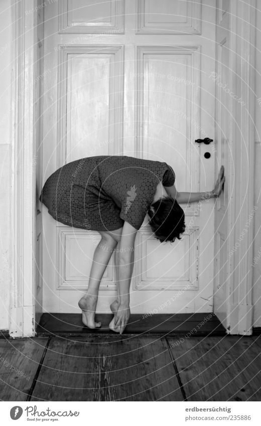 An der Schwelle - Frau steht in merkwürdig verkrümmter Haltung an Tür Dielenboden Türrahmen Türschwelle feminin Junge Frau Jugendliche Beine Fuß Kleid Barfuß