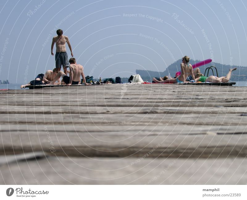 Auf dem Steg Holzbrett Mann Frau Bikini Italien See Meer San Felice del Benaco Gardasee Europa Mensch Jugendliche Bademoden Schwimmshorts Sonne Wasser