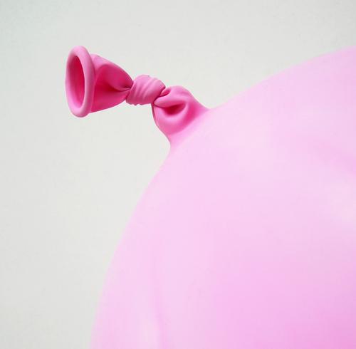 Rosa Gummi Luftballon Kunststoff Knoten rund rosa Farbfoto Innenaufnahme Nahaufnahme Detailaufnahme Menschenleer Textfreiraum rechts Hintergrund neutral Tag