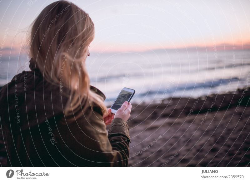 Junge Frau am Strand mit ihrem Smartphone Abenddämmerung Gefühle Glück Leben Lifestyle Spanien Sommer Sonne Sonnenuntergang Wärme Abenteuer Mitteilung Freiheit