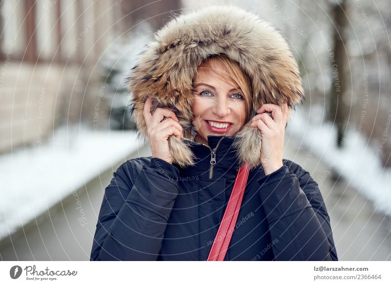 Porträt einer lächelnden Frau mit Winterhaube Lifestyle Glück schön Gesicht Schnee Erwachsene 1 Mensch 45-60 Jahre Park Mode Mantel Pelzmantel blond Lächeln