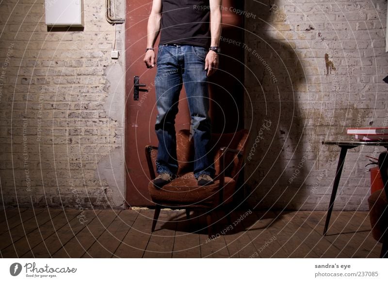 Türsteher Sessel Mensch maskulin Mann Erwachsene 1 Fabrik Bekleidung T-Shirt Jeanshose Armbanduhr Schuhe stehen warten dünn ruhig rot blau Wand Farbfoto