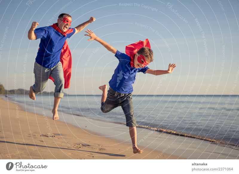 Vater und Sohn spielen tagsüber Superhelden am Strand. Lifestyle Freude Glück Leben Erholung Freizeit & Hobby Spielen Ferien & Urlaub & Reisen Abenteuer