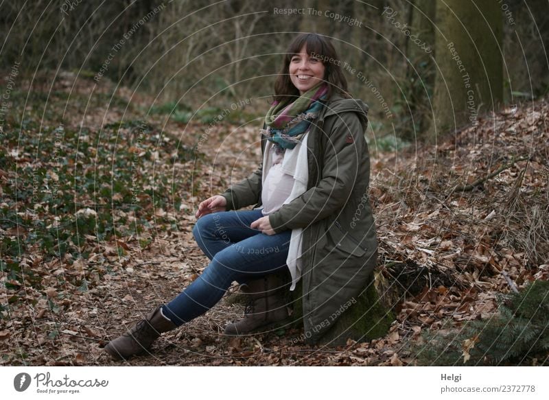 junge schwangere Frau mit langen Haaren sitzt lächelnd  im Wald auf einem Baumstamm Mensch feminin Junge Frau Jugendliche Erwachsene 1 30-45 Jahre Natur