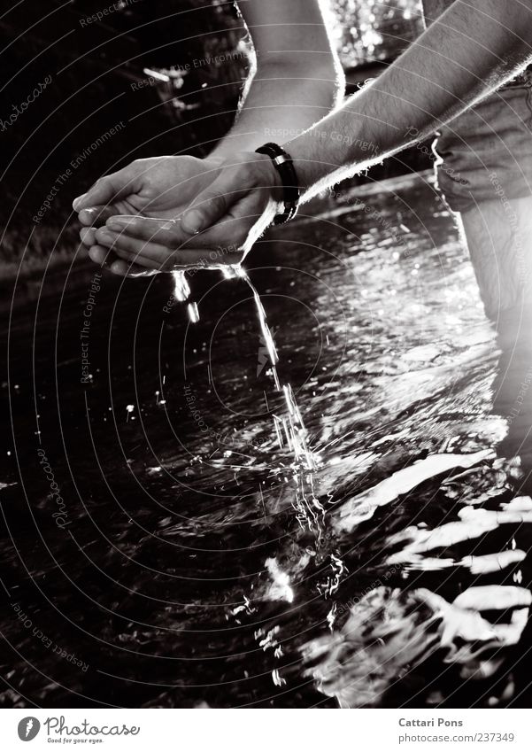 Wasserfänger 1 Mensch Wassertropfen Fluss berühren Bewegung glänzend stehen Flüssigkeit schöpfen Licht Hand tropfend Schwarzweißfoto Außenaufnahme Abend