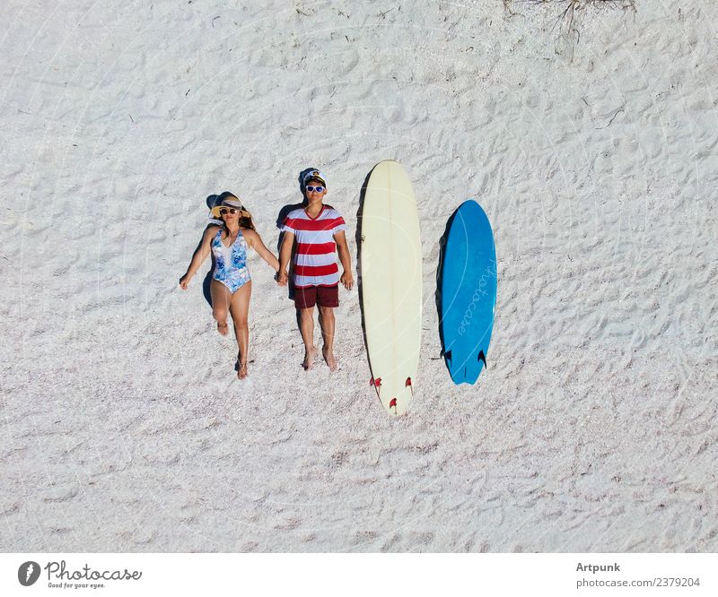 Luftaufnahme eines am Strand liegenden Surfpaares Surfen Antenne Dröhnen Surfbretter blau weiß Sand Paar Partnerschaft im Freien Sommer Romantik Surfer extrem