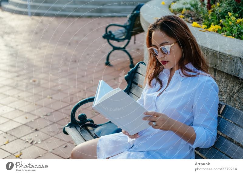Junge asiatische Frau beim Lesen eines Buches bibliophil lesen weiß Hemd Bank Park Bildung Schule Literatur sitzen Sonnenbrille Wort Bucheinband Erholung