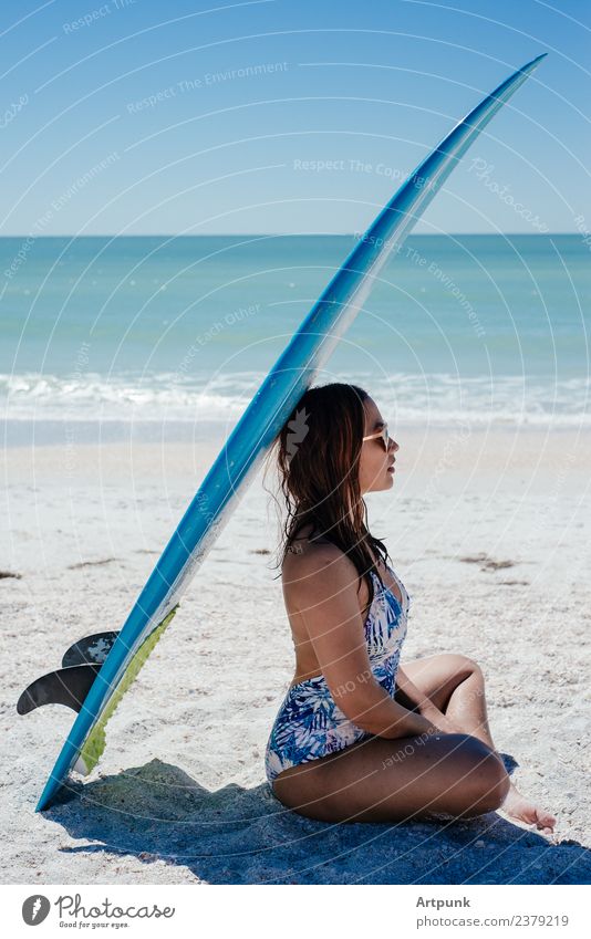 Eine junge Frau sitzt unter einem Surfbrett. 18-30 Jahre Lateinamerikaner Südamerika Asiate Sommer Strand Sand Sonne Meer Wasser Bikini langhaarig
