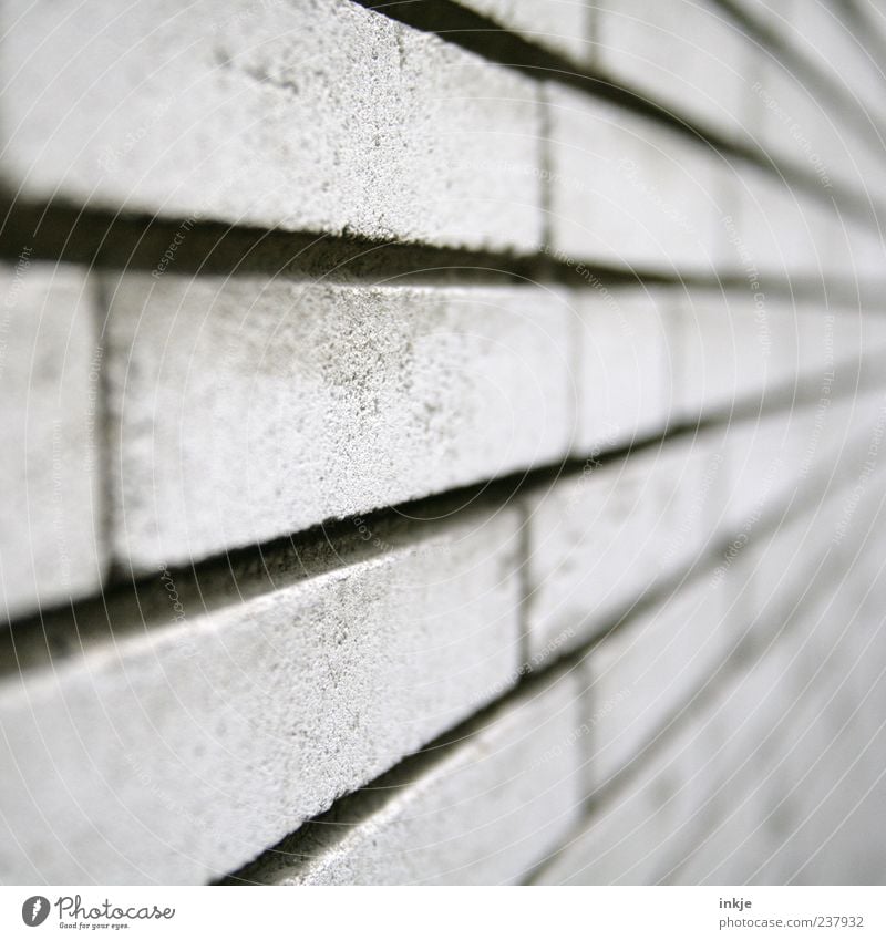 immer an der Wand lang Mauer Fassade Sandstein Steinwand Beton Backstein Linie Streifen kalt grau Fluchtpunkt Backsteinwand Farbfoto Gedeckte Farben