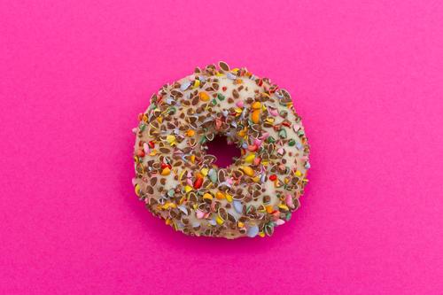 Zuckersüßer Donut auf pinkem Hintegrund Lebensmittel Kuchen Süßwaren Krapfen Essen Duft Glück lecker mehrfarbig rosa Laster Appetit & Hunger genießen Ernährung