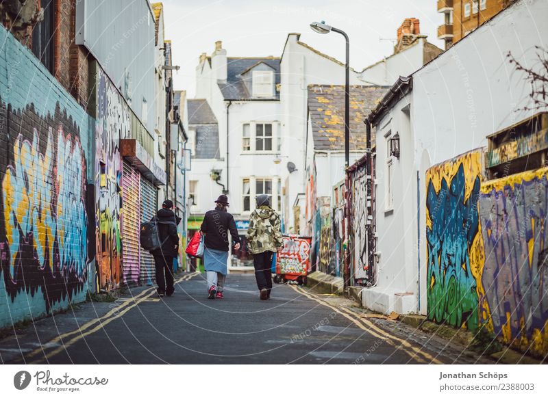 Jugendliche in einer Gasse in Brighton, England Stadt Stadtzentrum Stadtrand Haus Gebäude Architektur Fassade ästhetisch mehrfarbig Graffiti Müll Müllbehälter